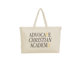 A cream canvas tote bag with long handles, featuring the text 'ADVOCATE CHRISTIAN ACADEMY' printed in black with gold accents on the front, set against a plain white background.